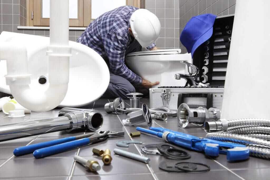 Plumber installing pipework beneath a bathroom basin