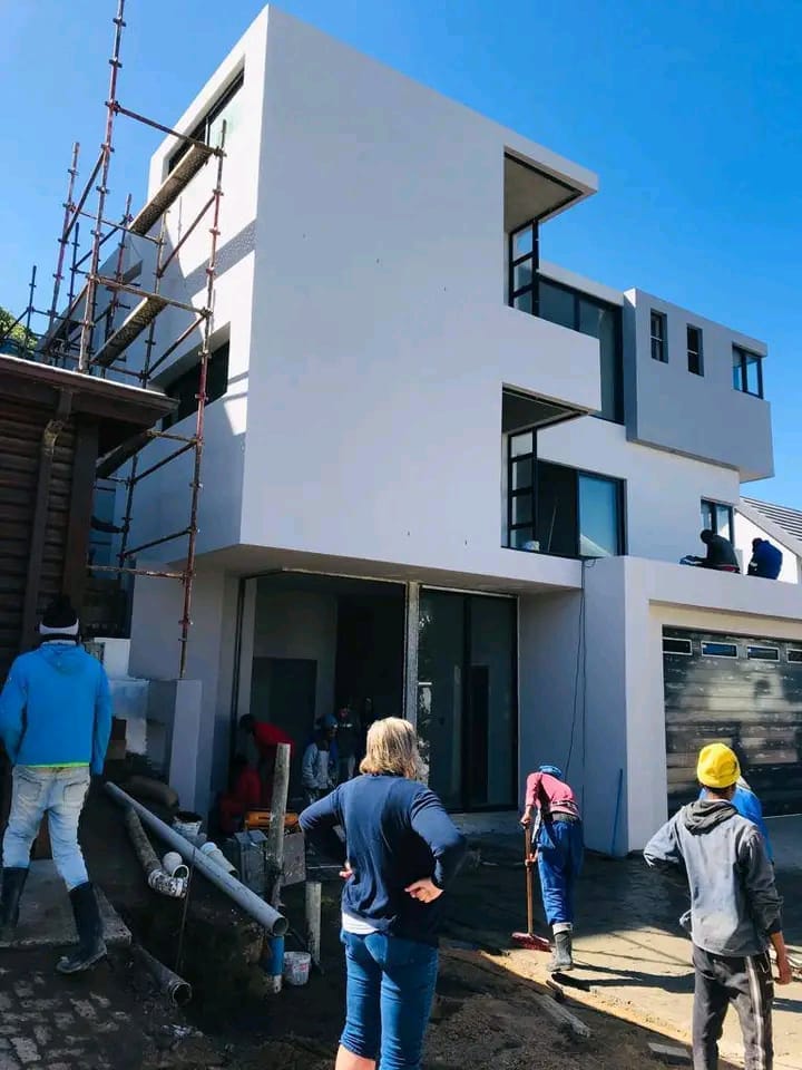 Construction team standing in front of a multi-storey home being built in Cape Town