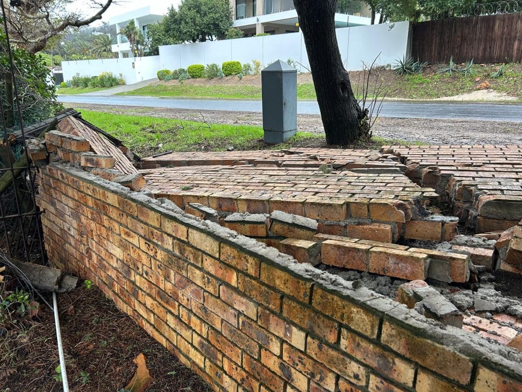 Exposed brickwork on a damaged garden wall in Cape Town
