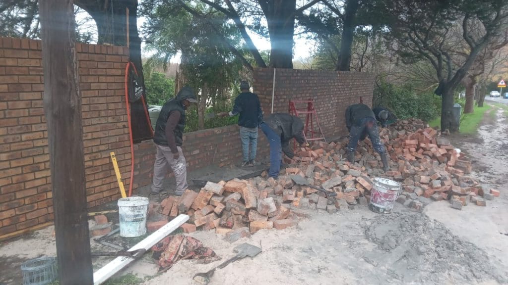 Builder laying a brick wall on a Cape Town building site