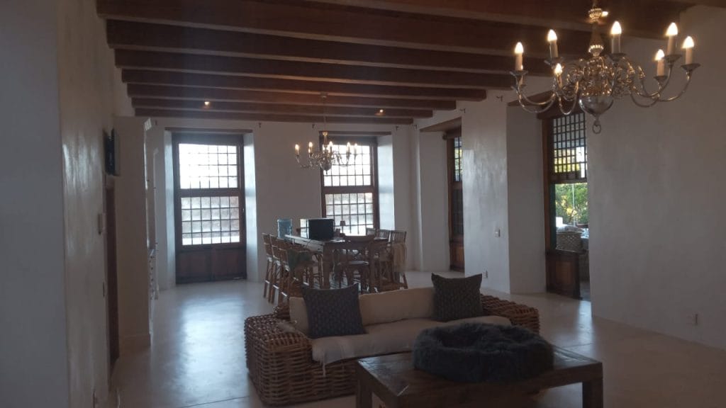 Living room with a dark timber beamed ceiling in an older Cape Town home