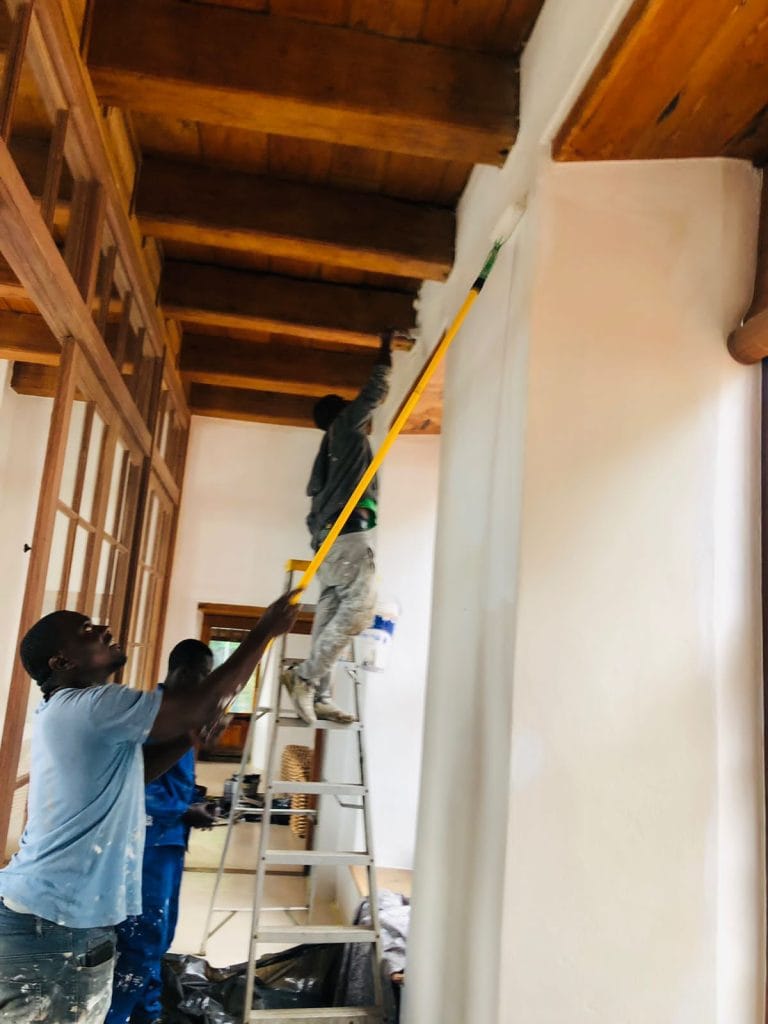 Worker on a ladder fitting a timber ceiling inside a Cape Town home