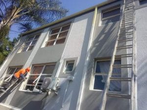 Home exterior renovation with workers and scaffolding in Cape Town