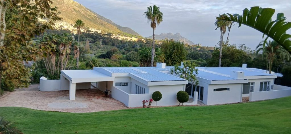 White estate home with pool and palm trees in Cape Town