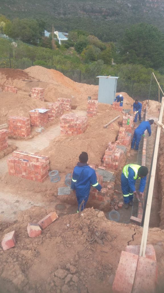 Workers laying foundation brick in Cape Town
