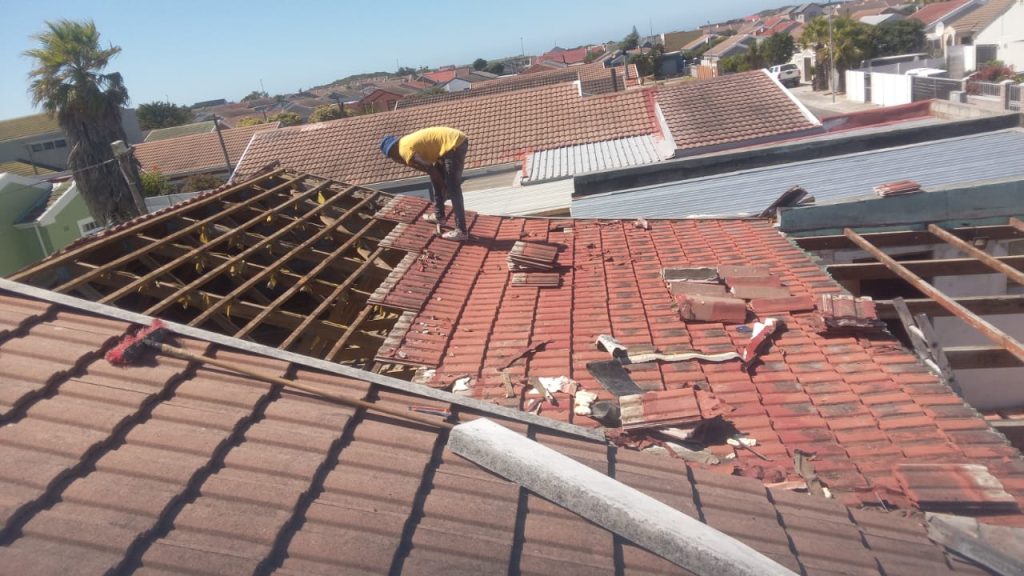 Roofers stripping old tiles and battens from a Cape Town roof