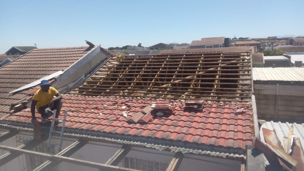 Worker stripping old roof tiles in Cape Town