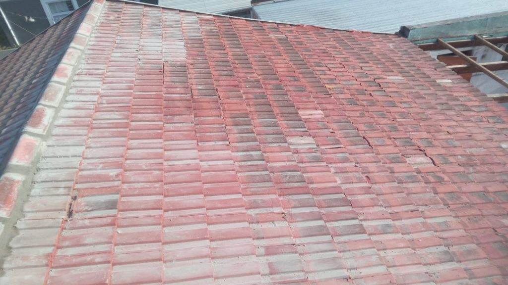 New terracotta roof tiles being laid on timber battens