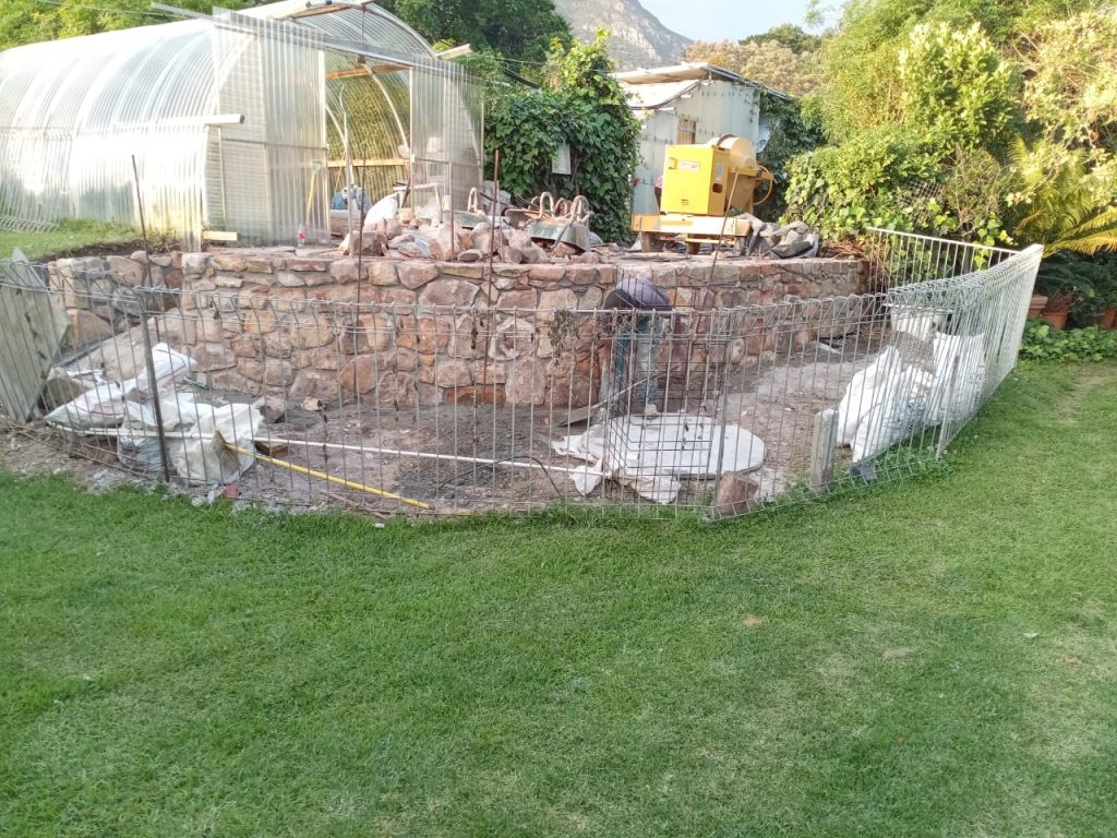 Stone wall and greenhouse in a garden in Cape Town