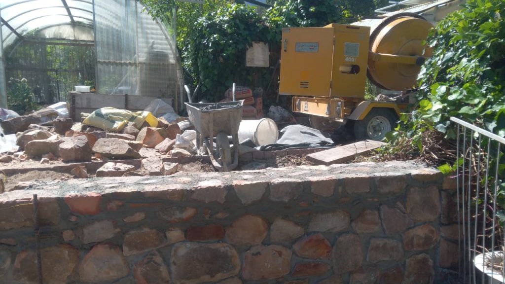 Stone wall construction with an excavator in Cape Town