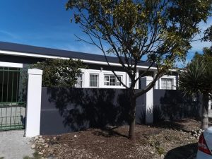 Renovated dark-grey house exterior with white-framed windows