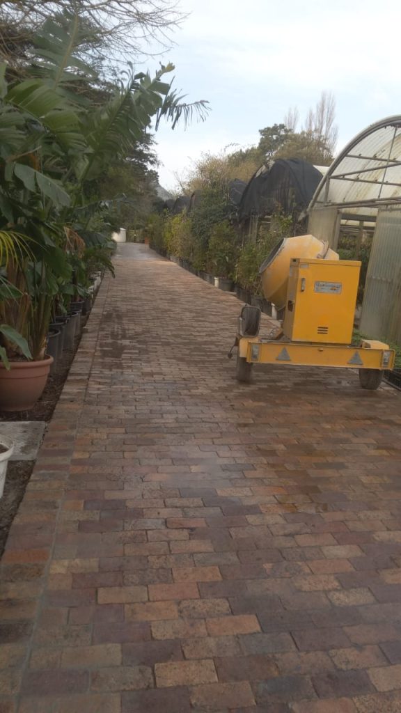 Worker on a roof above a paved driveway in Cape Town