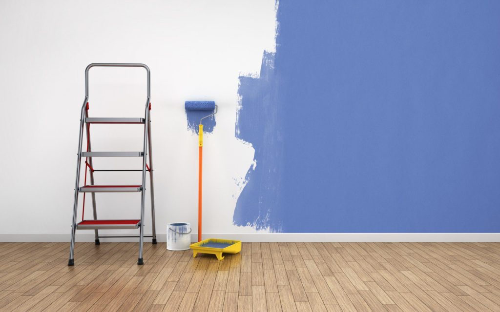Painter applying blue paint to an interior wall