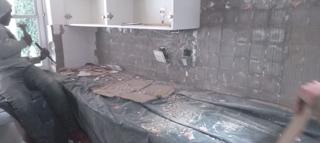 Kitchen stripped out with rubble ready for removal during a Cape Town renovation