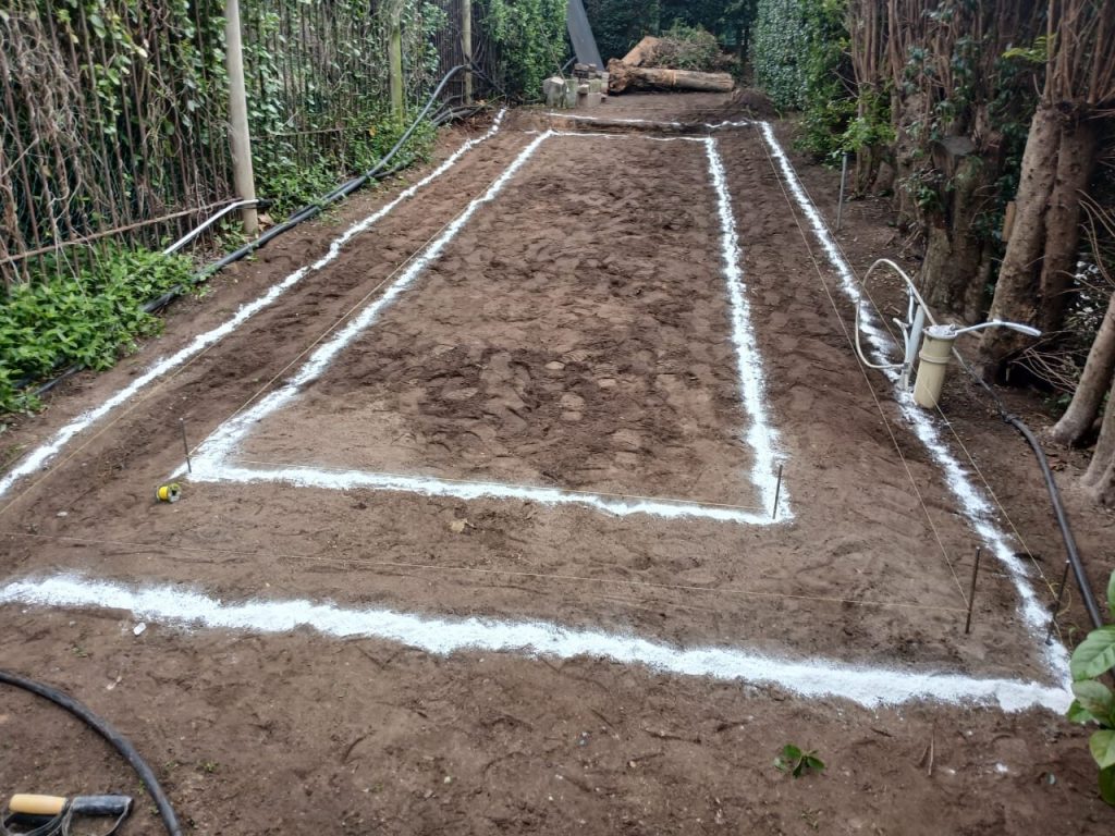 Foundation trench lines marked out in white on a cleared Cape Town building site