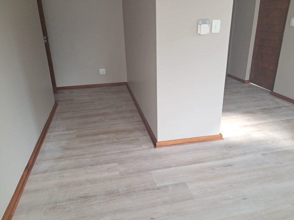 Finished interior room with laminate flooring and freshly plastered walls in a Cape Town home